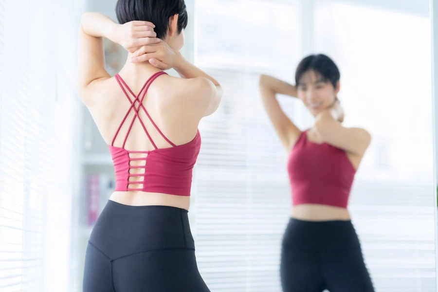 体型を確認する女性の背中。痩せすぎによる栄養問題と、理想的なボディバランスの考え方